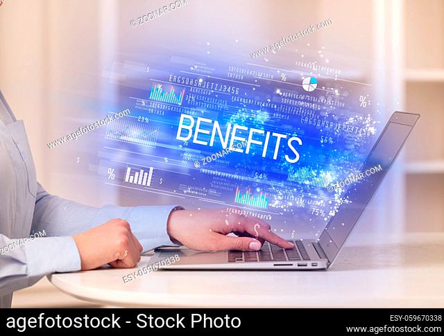 Closeup of businessman hands working on laptop with BENEFITS inscription, succesfull business concept