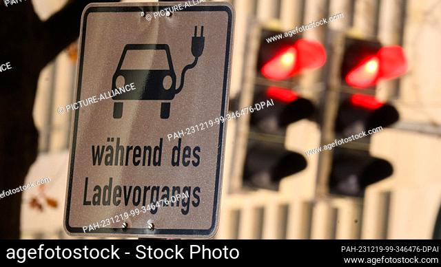 19 December 2023, Lower Saxony, Hanover: A sign with a symbol for an electric car and the words ""while charging"" marks a parking space at a charging station