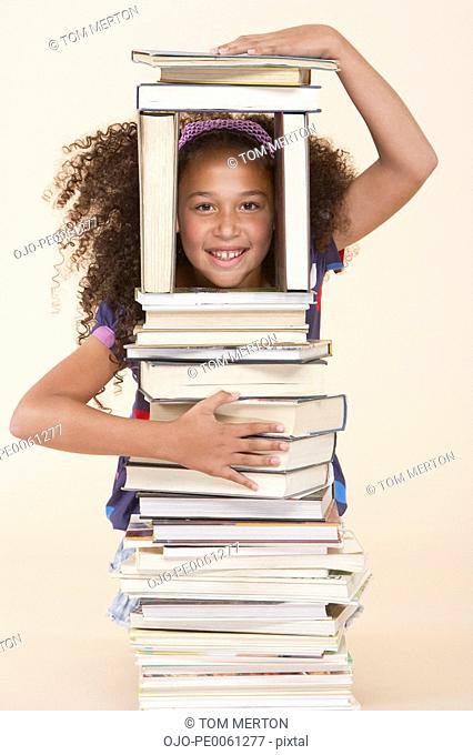 Young girl playing with books indoors