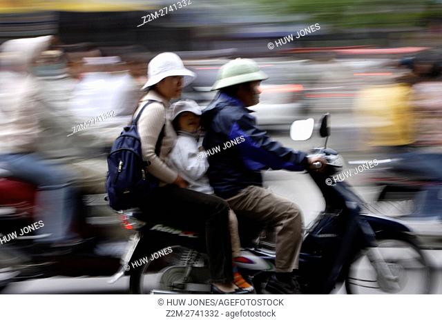 Family on a scooter in traffic, Hanoi, North Vietnam
