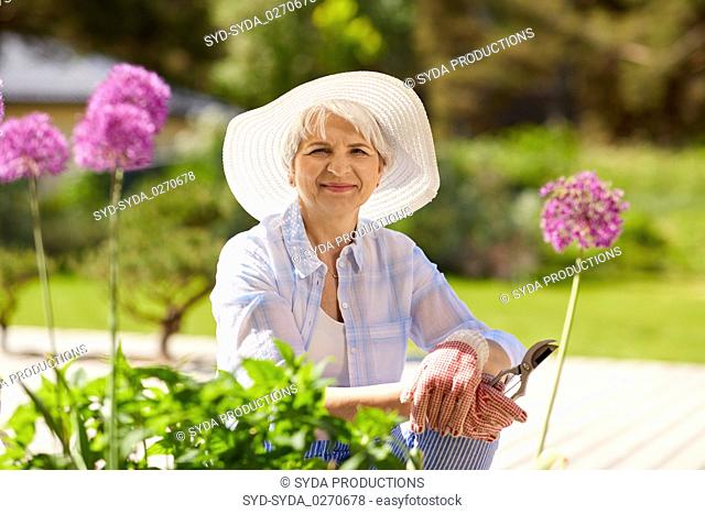senior woman with garden pruner and flowers