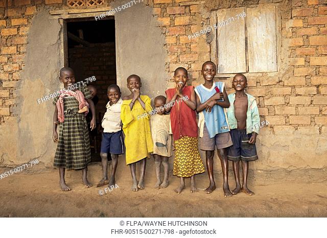 Happy smiling children standing outside home, Uganda, June