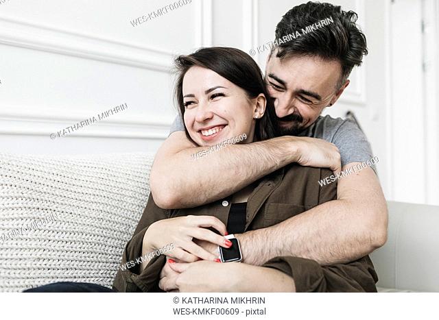 Happy couple embracing at home