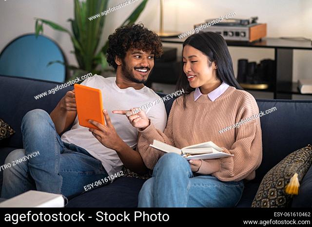 Talks. Young man and woman sitting on the sofa and talking