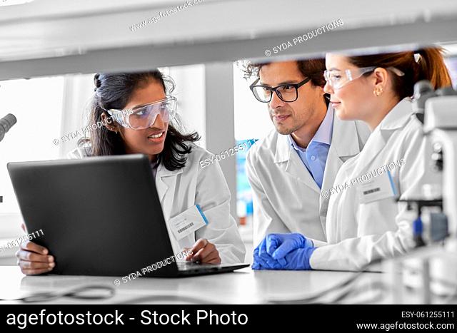 scientists with laptop working in laboratory