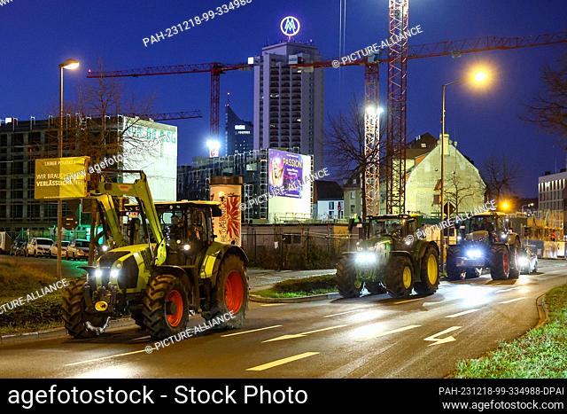 18 December 2023, Saxony, Leipzig: Several farmers drive their tractors through rush-hour traffic in the early morning. Farmers want to mobilize in Berlin on...