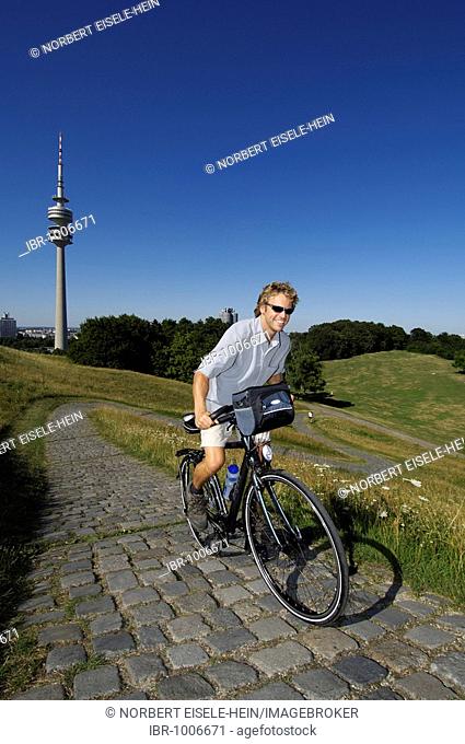 Cyclist on cycle tour, Olympiaturm, Olympiazentrum, Munich, Bavaria, Germany, Europe