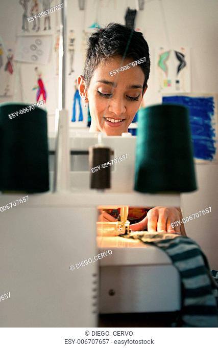 Small business and self-employed women, young hispanic woman working as fashion designer with sewing machine in studio