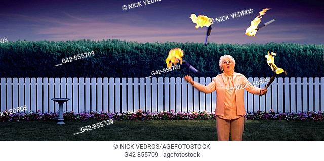 Grandmother juggling lit fire batons