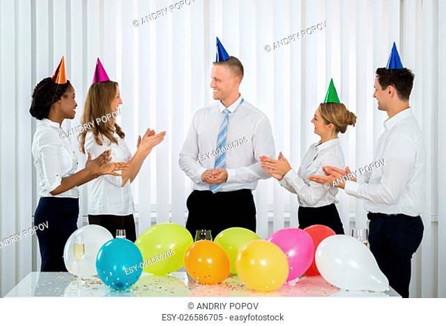 Group Of Businesspeople Applauding To The Manager During Party In Office