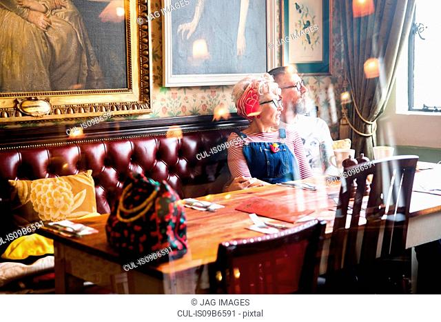 Quirky couple relaxing in bar and restaurant, Bournemouth, England