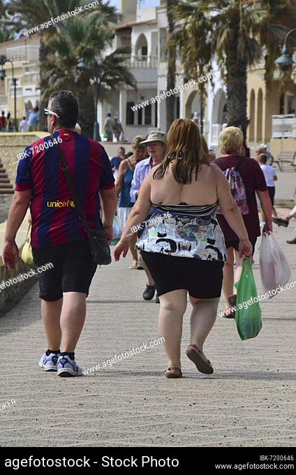 Overweight couple with plastic bags on beach promenade, Villaricos, Andalusia, Spain, Europe