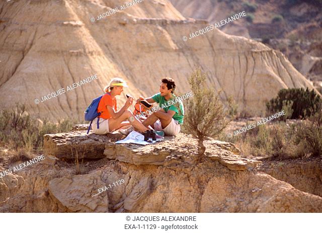 Couple with backpacks on rock cliffs