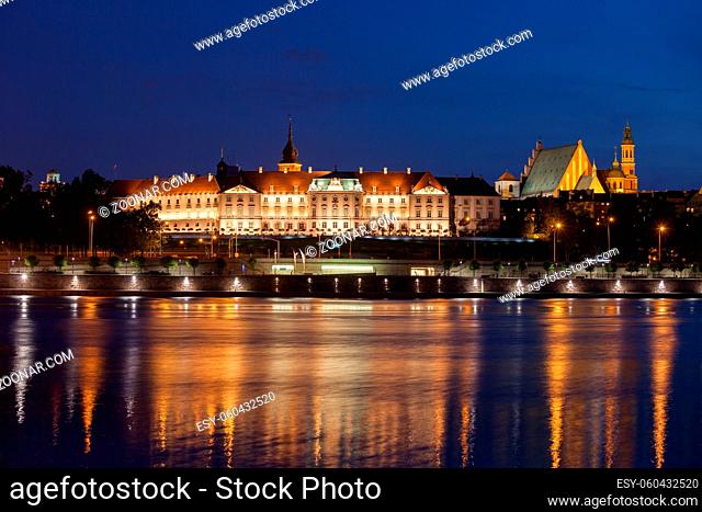 Royal Castle in city of Warsaw, Poland illuminated at night, historic city landmark, view across Vistula River, Baroque and Mannerist architecture
