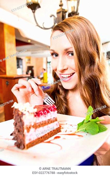 Woman eating cake at pastry shop cafe