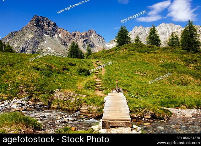 Mountain landscape with river and wooden bridge, Alpe Devero, italy