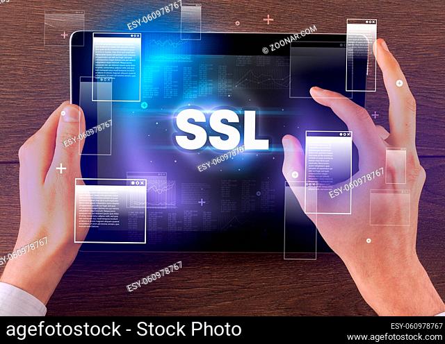 Close-up of a hand holding tablet with SSL abbreviation, modern technology concept