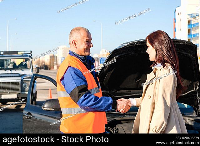 Woman greeting mechanic after her car breakdown