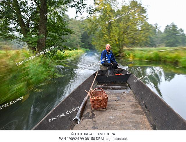 24 September 2019, Brandenburg: Harald Wenske drives with an empty Spreewald barge in the morning over a river to fetch pumpkins from the field