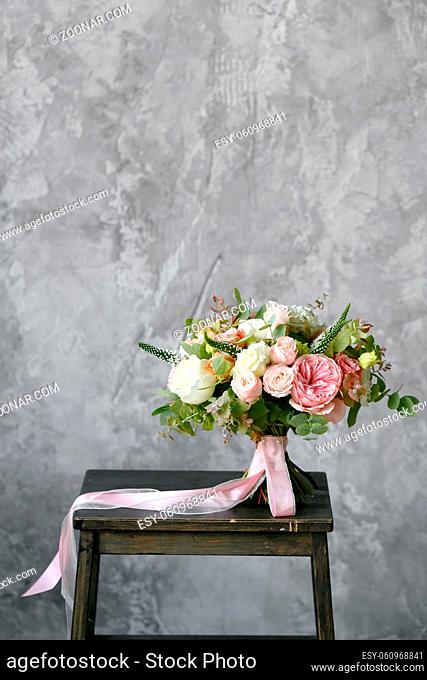 Spring bouquet of white lilacs in vintage gray enamel vase, white wall background behind. luxury wedding bouquet made by a professional florist