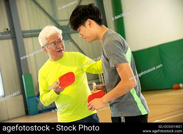 Senior and young people enjoying table tennis