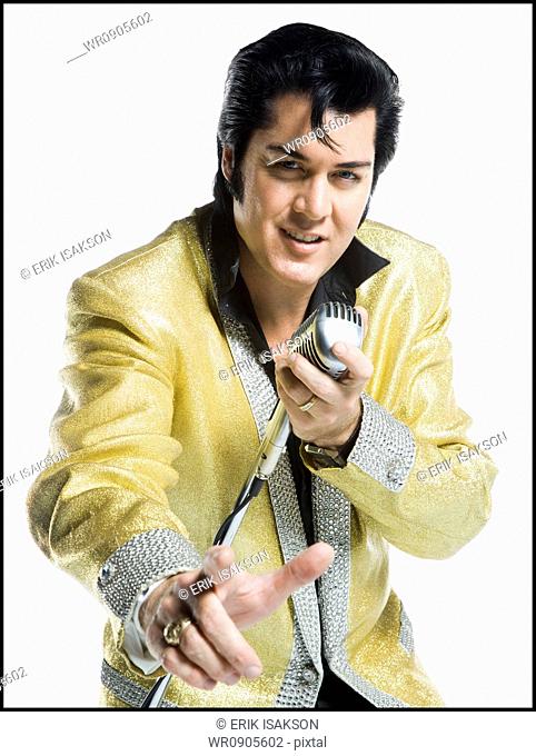 Portrait of an Elvis impersonator singing into a microphone