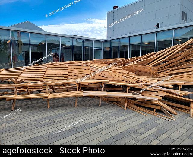 pile or mound of wood tables and chairs outside building with windows