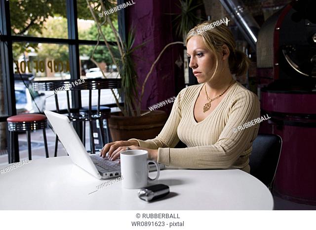 Young woman using a laptop in a Caf