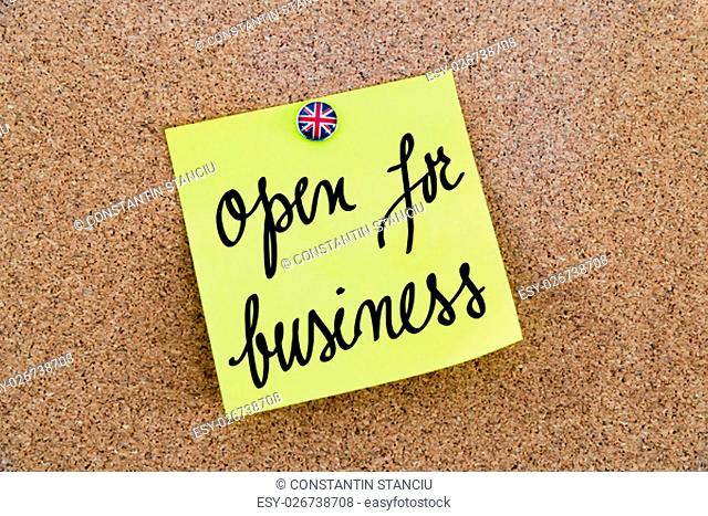 Yellow paper note pinned on cork board with Great Britain flag thumbtack, written text Open For Business, British Business concept