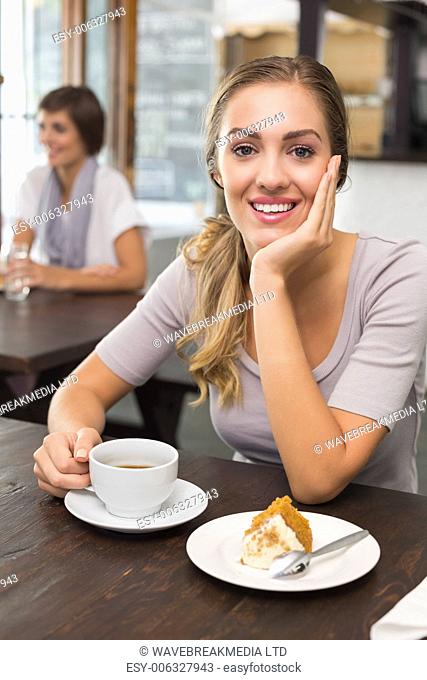 Pretty blonde enjoying cake and coffee at the coffee shop