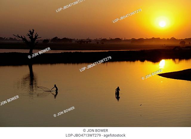 Myanmar, Mandalay, Lake Taungthaman. Fishermen on Taungthaman Lake in Myanmar at sunset viewed from U Bein Teak Bridge