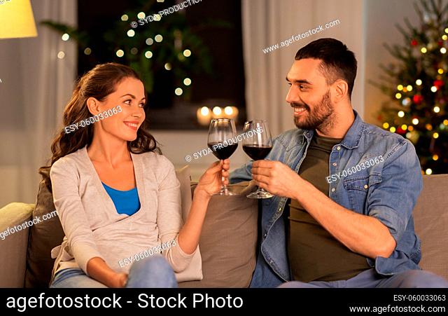 happy couple drinking wine at home on christmas