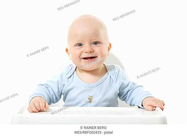 Baby boy 6- 11 Months on high chair, smiling, portrait