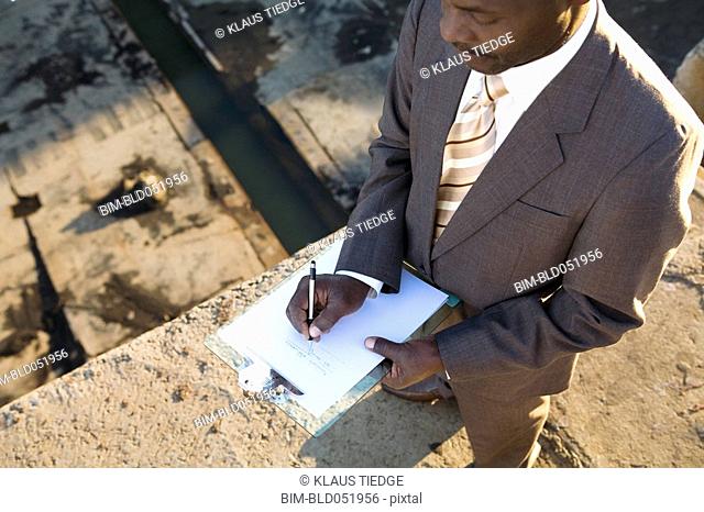 African American businessman writing on clipboard