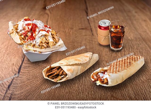 Doner kebab, pita sandwiches and cola on wooden background. For fast food restaurant design or fast food menu
