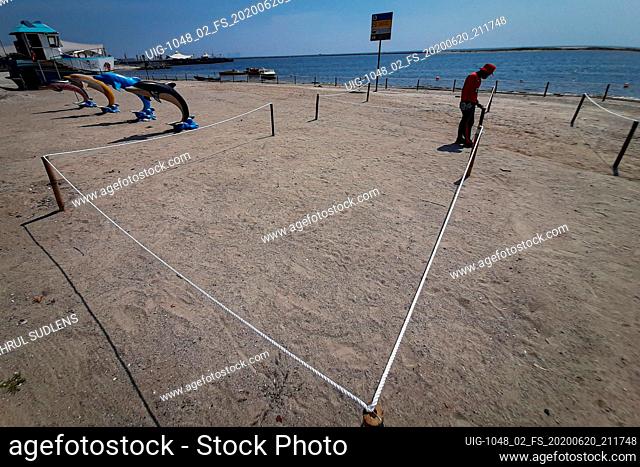An officer seen preparing line area at the Ancol beach after the Jakarta government reopens recreation parks at Dunia Fantasi in Jakarta, Indonesia on June 20