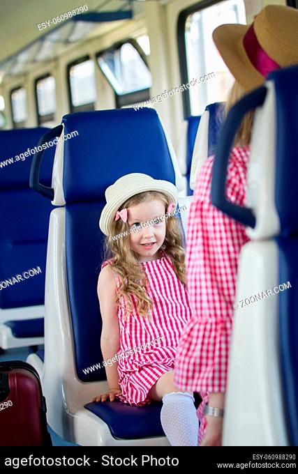 Cute little daughter sitting in front of her mom in train, close up