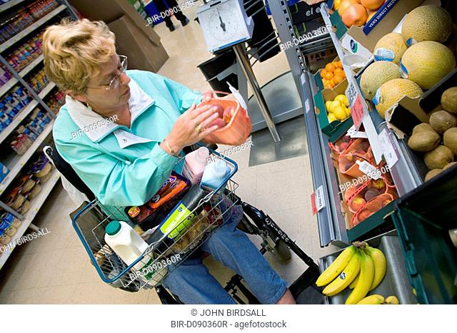 Woman wheelchair user shopping in a supermarket