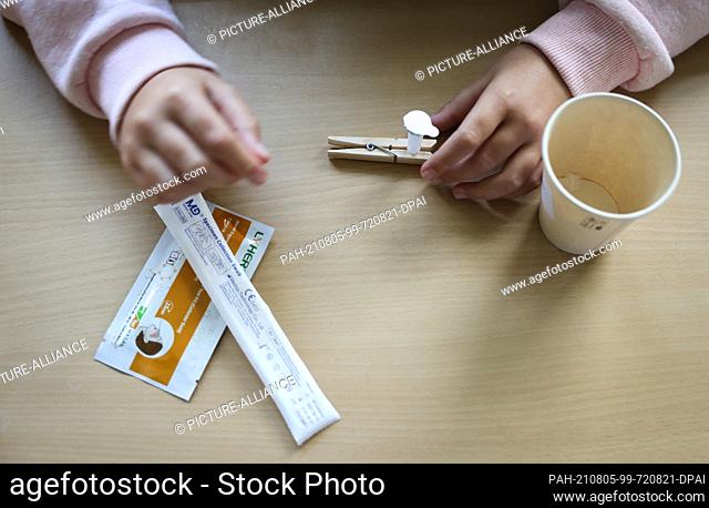 05 August 2021, Hamburg: A pupil in class 6a at the Goethe-Gymnasium in Hamburg-Lurup takes a Corona quick test in the classroom on the first day of school...