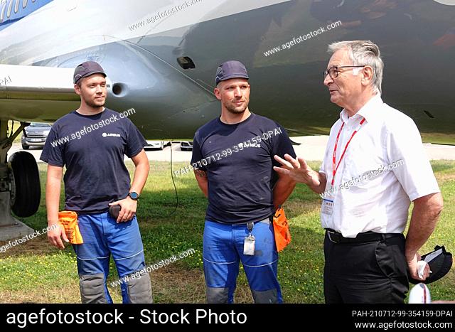 12 July 2021, Hamburg: Two trainees stand next to Rolf Klaus Peters, a member of the Friends of the ""VFW614"" museum aircraft