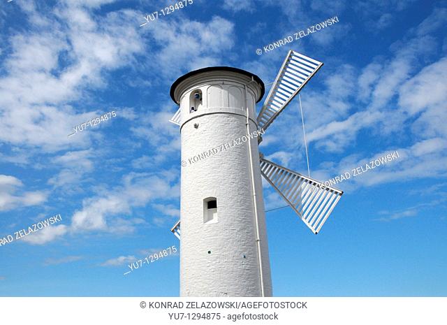 Beacon 'Windmill' on stone pier next to port entry in Swinoujscie at Baltic Sea, Poland