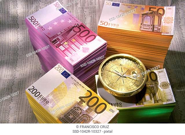 Stack of Euros and a compass