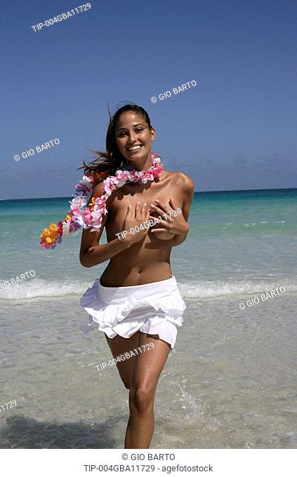 Topless woman running on beach