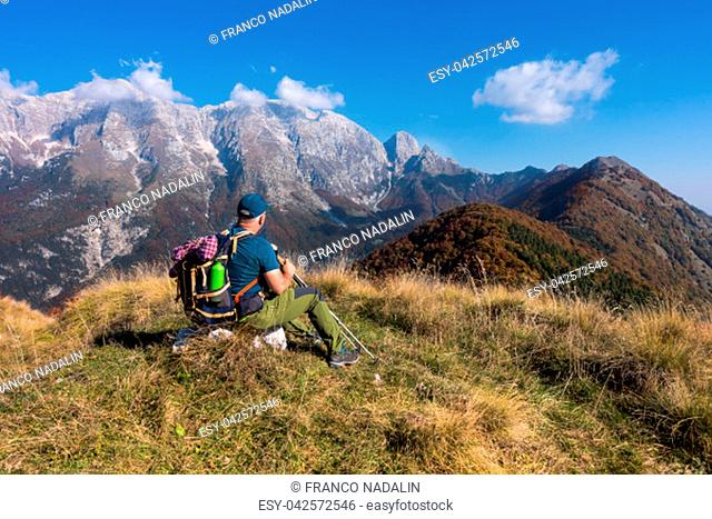 Man hiker sit and watch the landscape of mountain in autumn from the mountain top