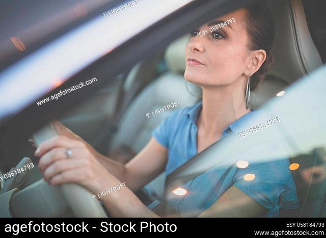 Pretty, young woman driving a car -Invitation to travel. Car rental or vacation