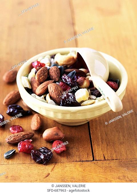 Snack Mix, Nuts and Dried Fruit in a Bowl with Measuring Cup Scoop