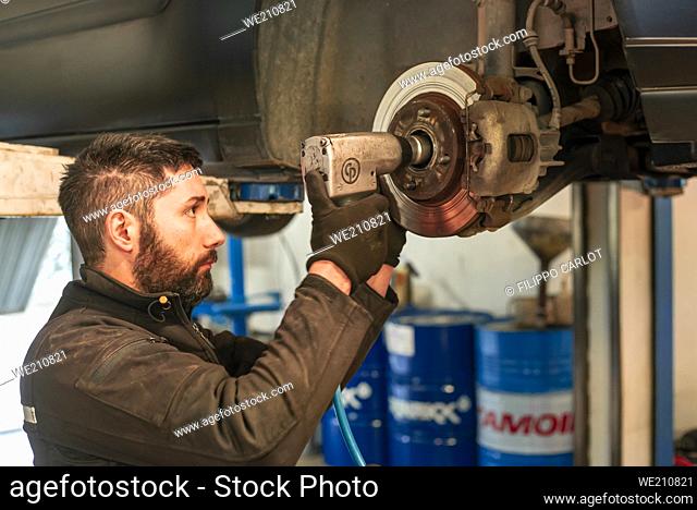 MILAN, ITALY: Mechanic performs maintenance on the car in the workshop