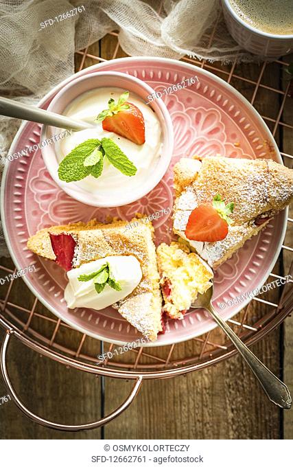 Simple and light sponge cake with fresh strawberries served with cream and mint