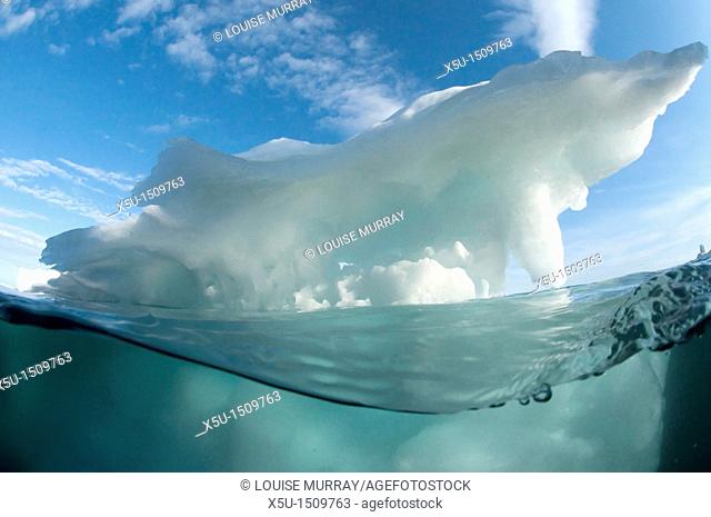 Iceberg split shot showing view of above and below the water, photographed in the Foxe Basin, Nunavut, Canada