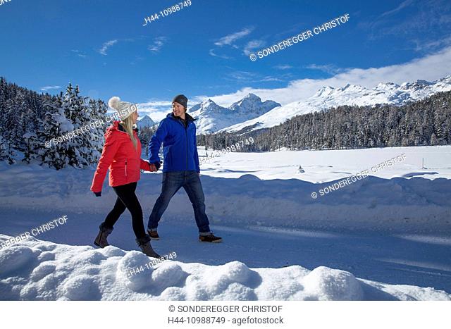 Couple walking at Statzersee near Saint Moritz in winter in Grisons